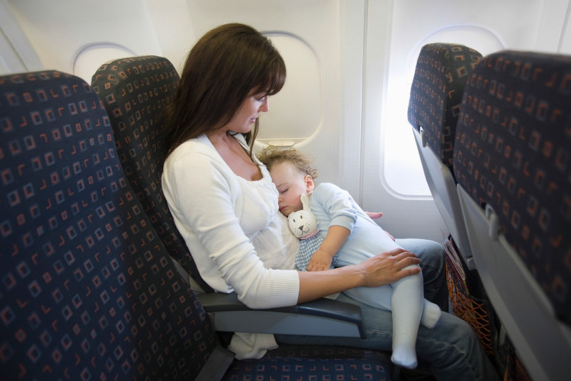 bebe en regazo de adulto en un avión