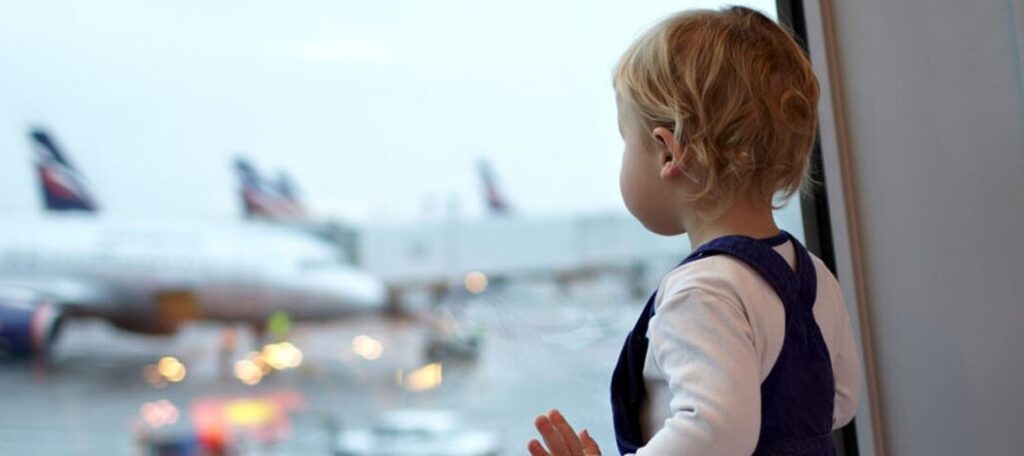 bebe mira por ventana en aeropuerto